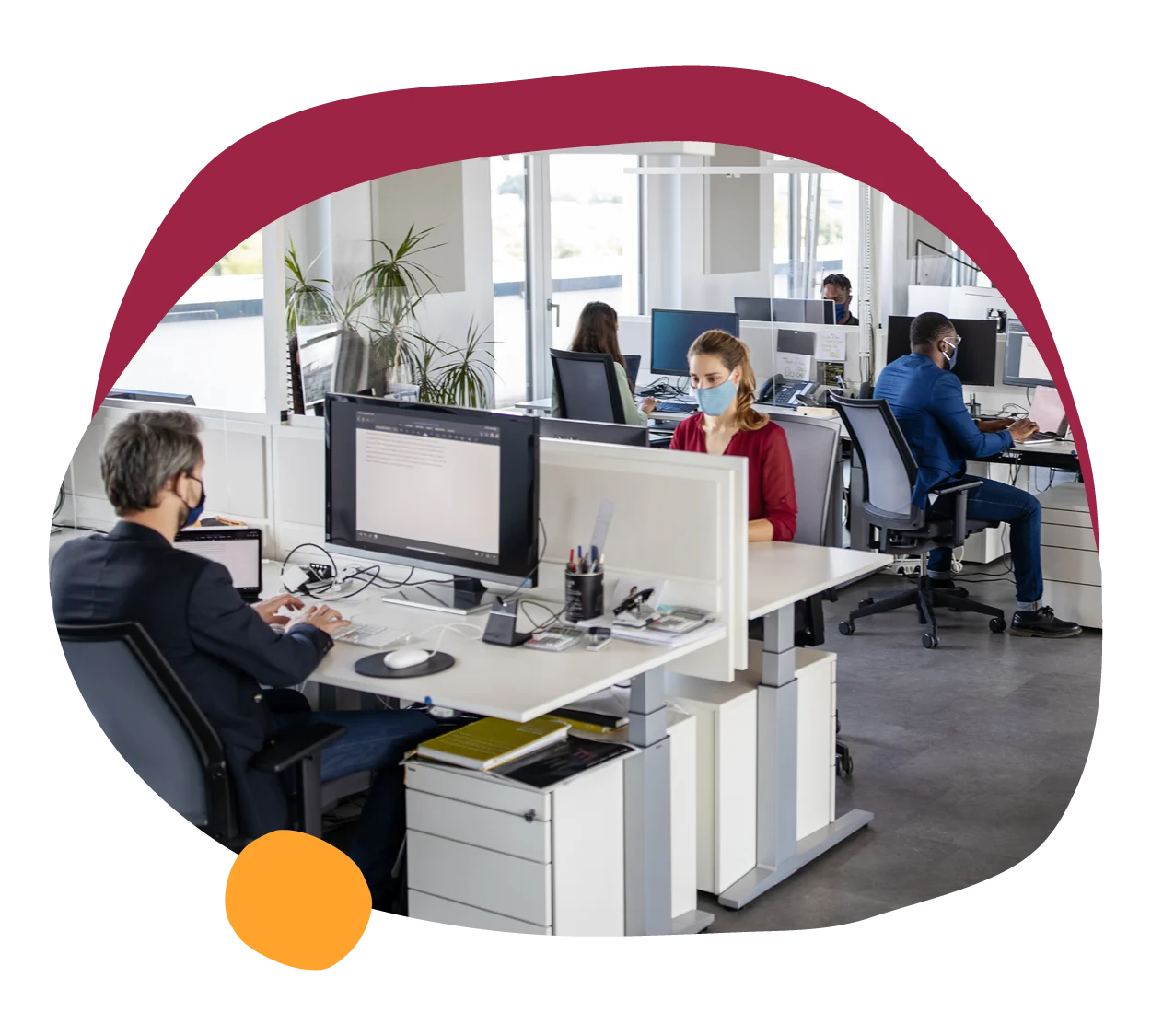 office workspace with employees in masks, modern desk arrangements and technology in a bright environment