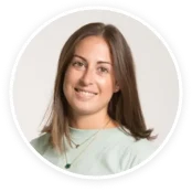 smiling woman with long brown hair wearing a light green shirt, casual portrait in round frame, soft background lighting