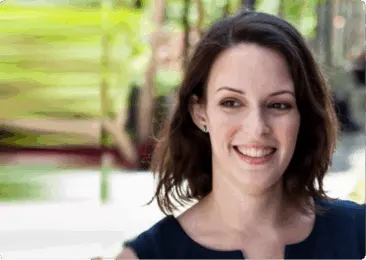 woman smiling in a garden, green blurred background with soft lighting