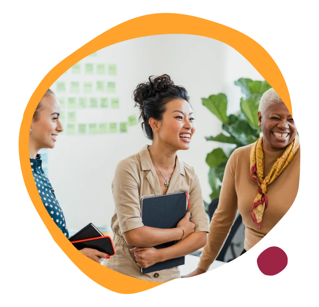 women laughing, diverse team in modern workspace