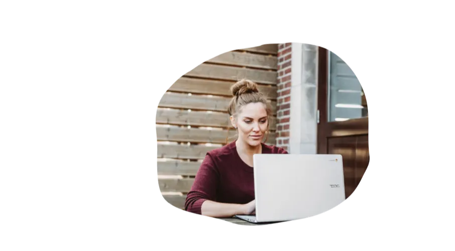 woman working on laptop, outdoor setting with wooden background