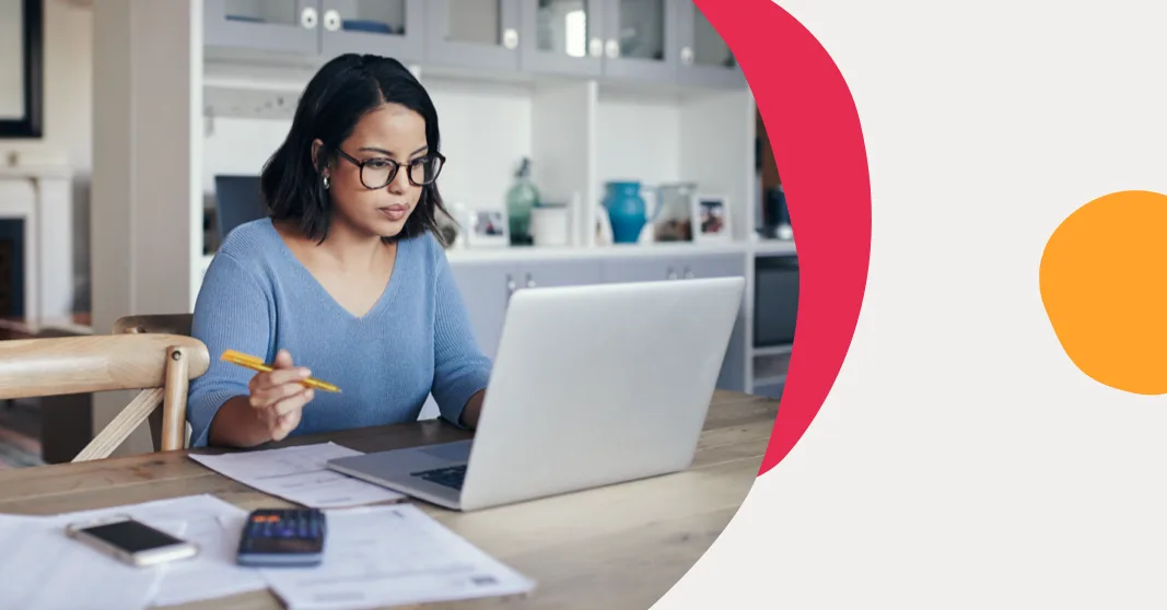 woman working at home desk with laptop, papers, calculator, and notebook in a modern living space, home office productivity scene
