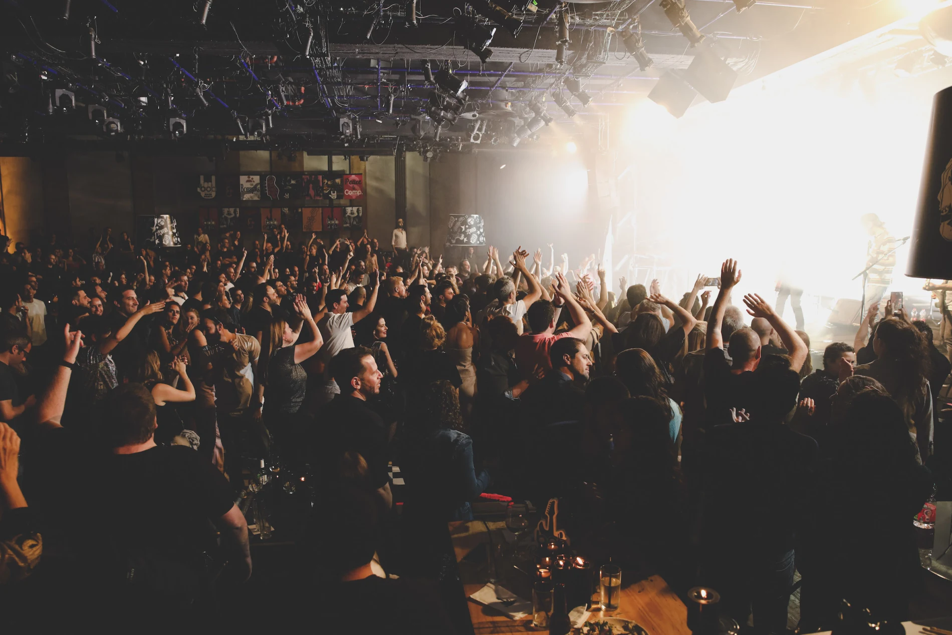 crowd enjoying a live concert with raised hands and a vibrant atmosphere, concert audience celebrating music energy and excitement