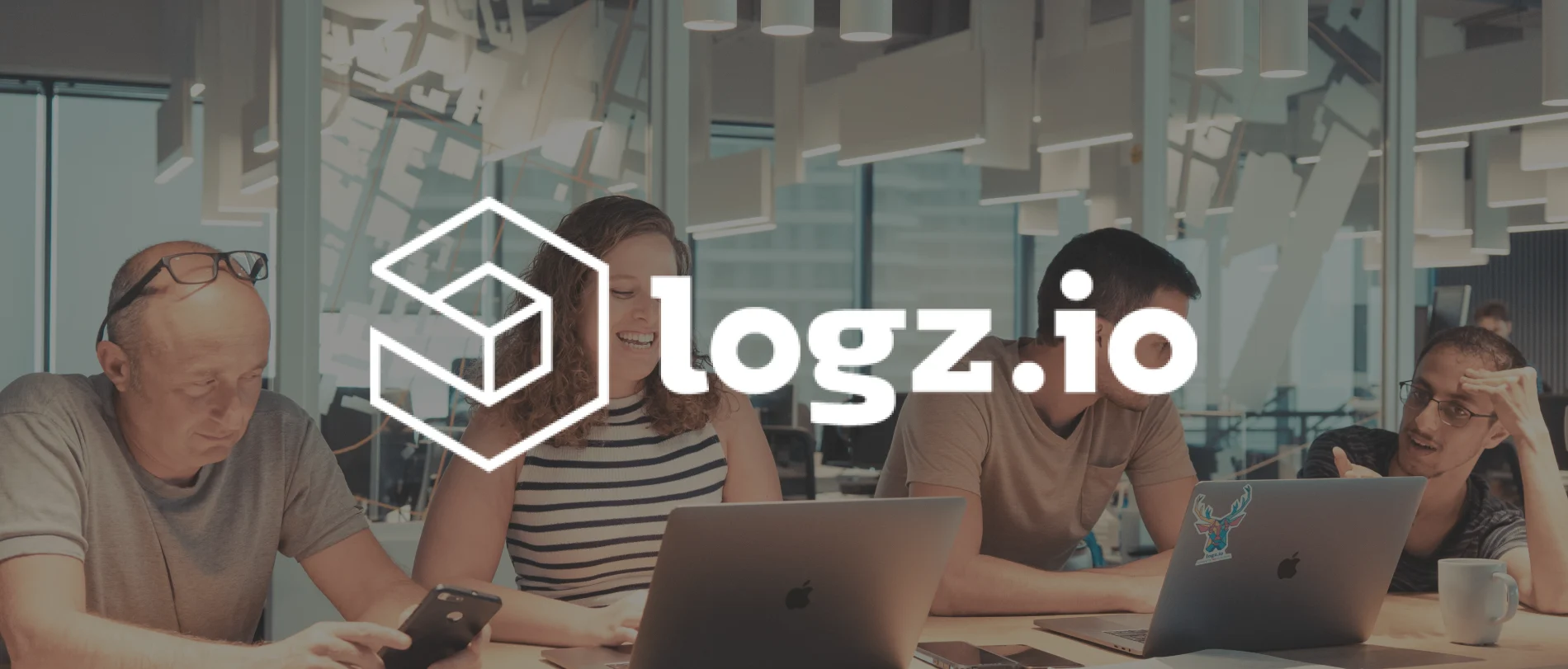 people working together in a modern office, logz.io branding and technology focus during a collaborative session