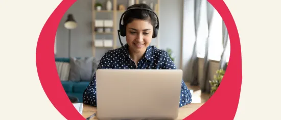 woman with headphones smiling at laptop in modern home office environment, remote work setup with cozy interior details