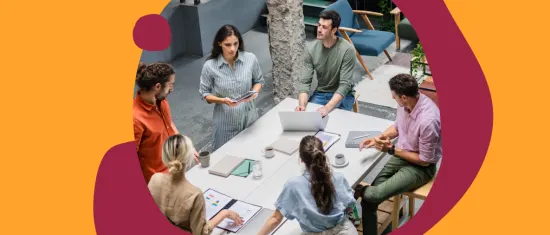 collaborative team meeting around a table with laptops, discussing ideas in a modern office space, diverse group brainstorming with digital devices