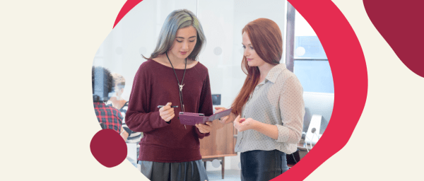 collaborative workspace, young professionals discussing ideas on a tablet in a modern office setting