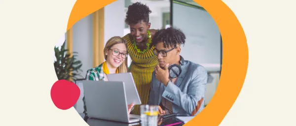 collaborative team working on a laptop in a modern office, diverse group engaged in discussion and problem-solving
