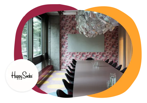 meeting room interior with colorful wave wallpaper and modern chandelier, Happy Socks branding visible on wall decoration