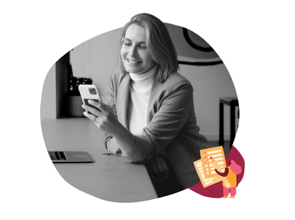 smiling woman in blazer uses smartphone at desk, with laptop nearby and creative note illustration, office setting with technology focus