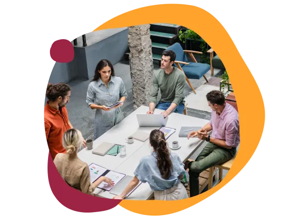 team meeting in modern workspace, collaborative discussion with laptops and documents on a stylish table