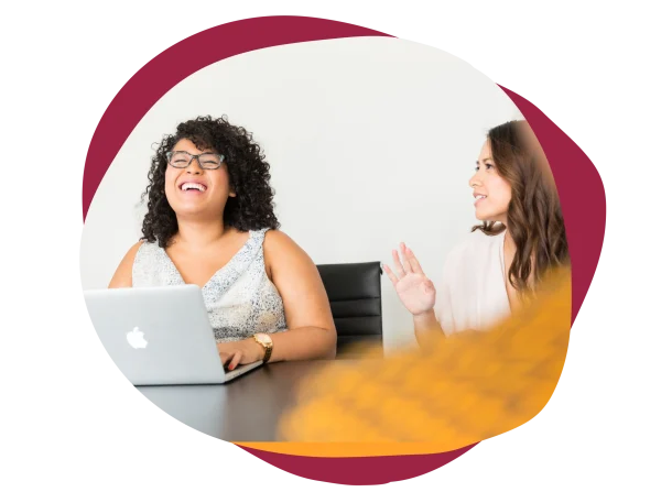 happy-women-laughing-office, women-discussing-laptop-table