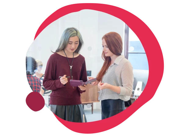 young women collaborating in a modern office, discussing ideas using a tablet, creative workspace atmosphere, collaboration and innovation in design studio setting