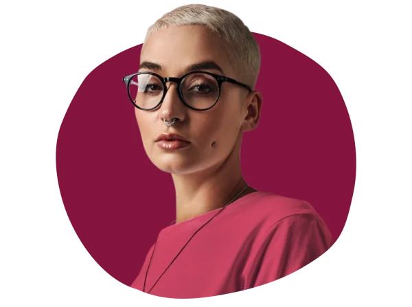 fashionable woman with short blonde hair and glasses wearing a pink shirt against a maroon background, modern portrait style