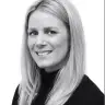 smiling woman with long blonde hair in a black turtleneck, plain white background, professional portrait, blonde woman smiling in monochrome photo
