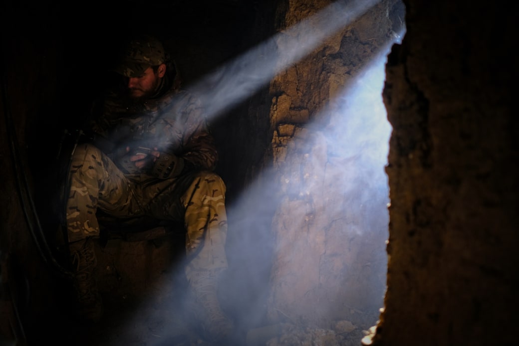 Fire (26), lid van eenheid CODE 9.2, zit diep in een koude, vochtige bunker bij Bachmoet. Hij stelt de laatste parameters in om de drone te besturen.