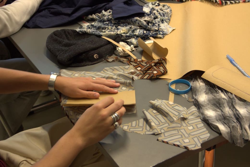 Jongeren 'upcyclen' oude kleren tot telefoonhoesjes.