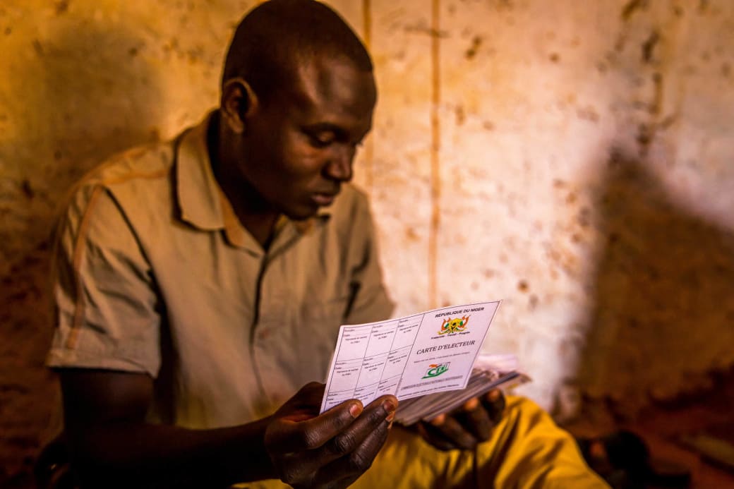 Een man houdt zijn stemkaart vast in het district Riad, Niamey.