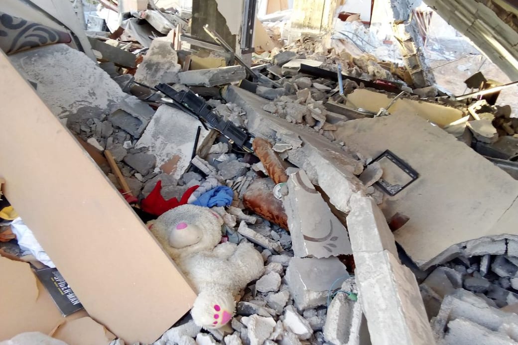 Foto van het vernielde huis van Islam Idhair en zijn gezin. Tussen het puin is een knuffelbeer zichtbaar.