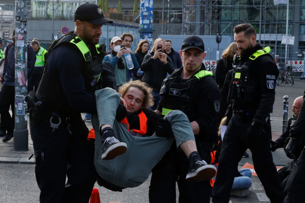 politieagenten dragen in Berlijn een demonstrant weg die deelneemt aan een vreedzame sit-in