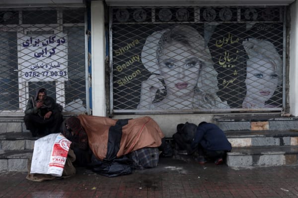 Januari 2022, mensen zitten voor een gesloten schoonheidssalon in de Afghaanse hoofdstad Kaboel.