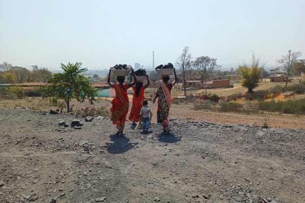 Uit de Amrapali-steenkoolmijn bij Hazaribagh komen vrouwen tevoorschijn met bijeenzochte stukken steenkool op hun hoofd.