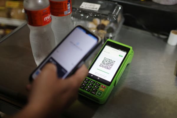 Een persoon betaalt met zijn mobiele telefoon via de elektronische betaalmethode Pix in een winkel in Rio de Janeiro.