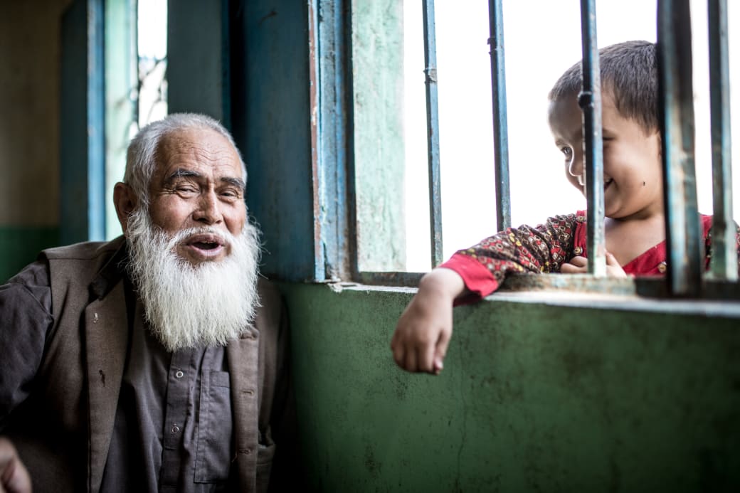 Een Afghaanse grootvader met zijn kleindochter in de Afghaanse basti of sloppenwijk nabij Karachi.