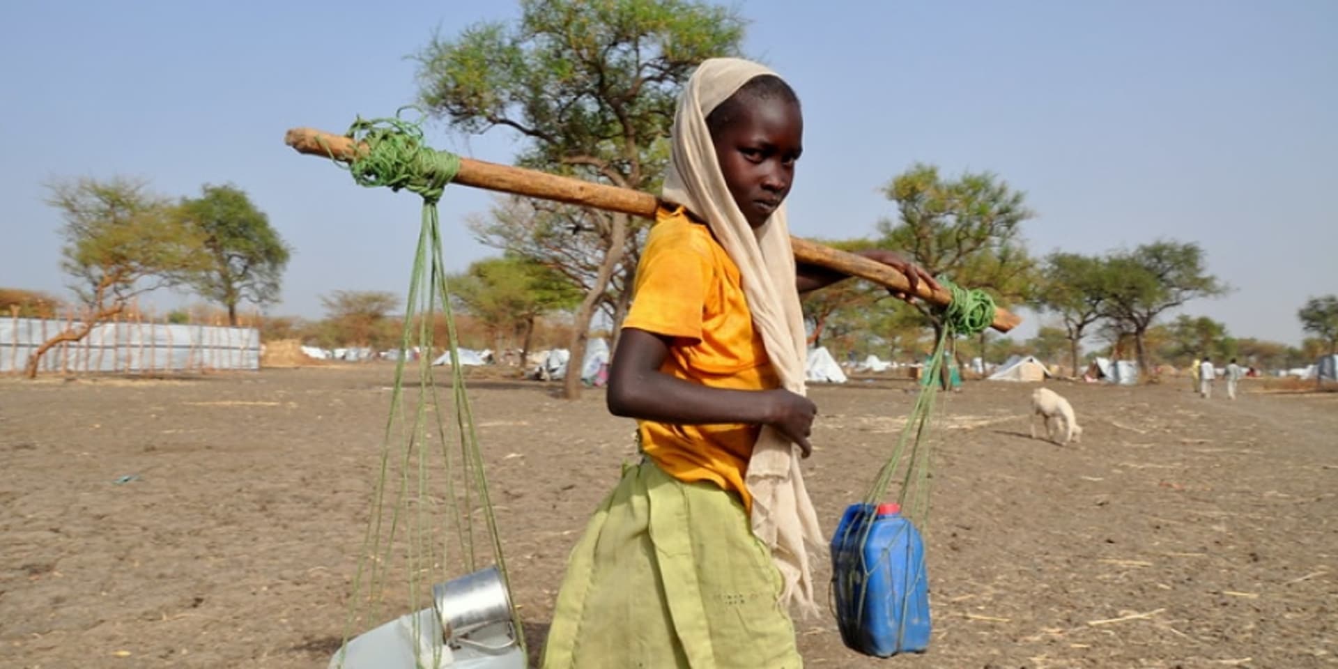 Jong meisje draagt water naar huis.