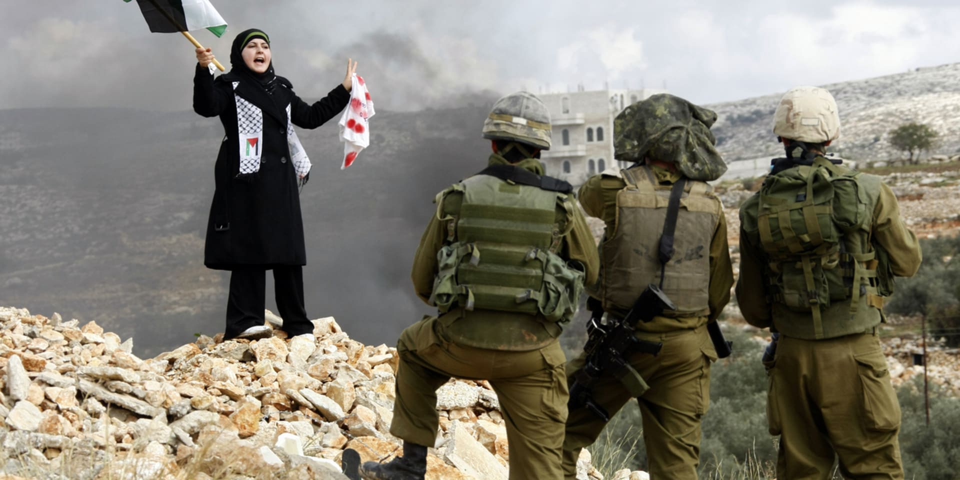Een Palestijnse vrouw protesteert in 2009 voor Israëlische soldaten tegen de belegering van Gaza. De militaire controle-infrastructuur in de Palestijnse gebieden is niet tijdelijk, ze is een permanent schild.