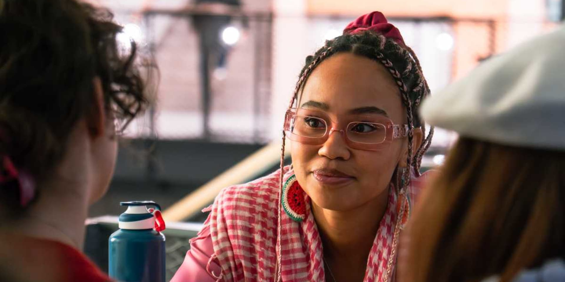 Influencer en klimaatactiviste Mikaela Loach kijkt naar haar gesprekspartners recht tegenover zich, net naast de lens.