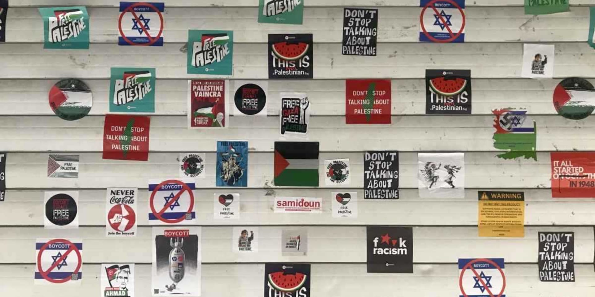 Beeld van flyers met onder andere 'Free Palestine'-boodschappen op een rolluik.