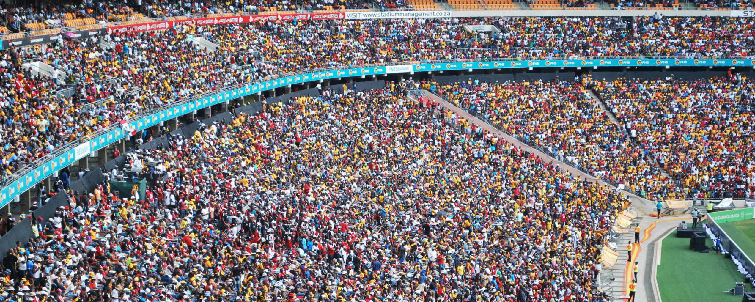 Zuid-Afrikanen in het stadion in Johannesburg. ‘We rijden langs een historische site waar Nelson Mandela ooit het leven zuur werd gemaakt. Het is wachten op de eerste kapitalist die er een themapark naast bouwt.’