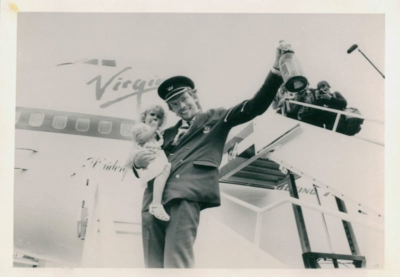 Richard holding his daughter Holly as he celebrates launching Virgin Atlantic