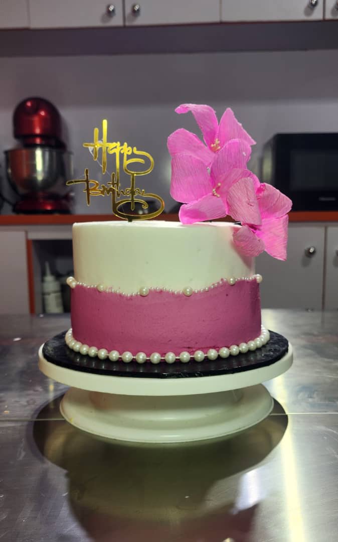 Pink and white buttercream cake with a large pink bow