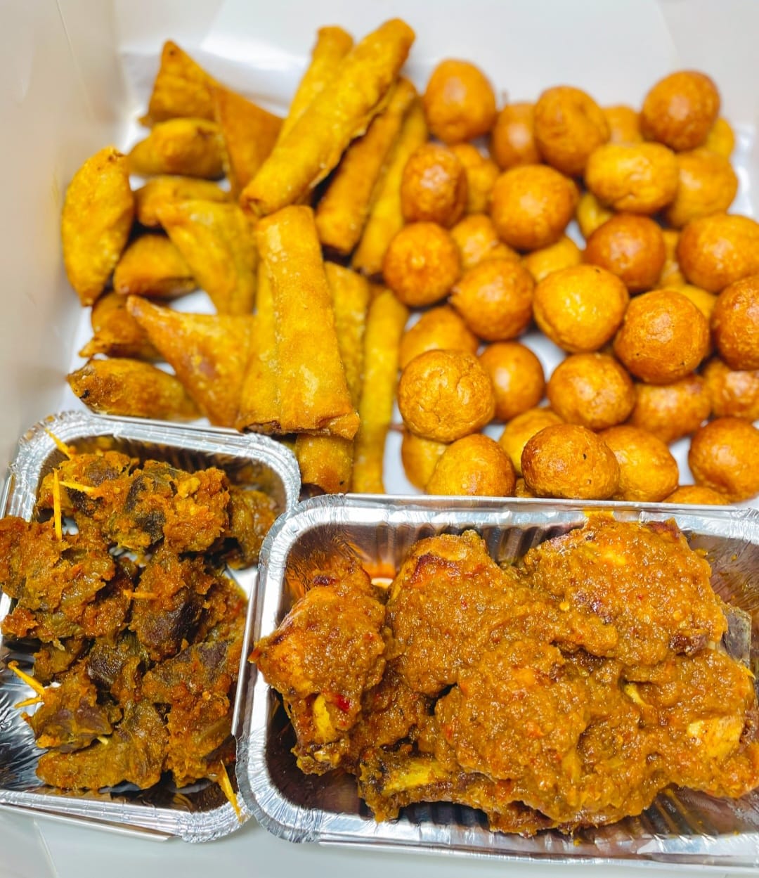 Large foil platter with spring rolls, puff-puff, samosas and meat