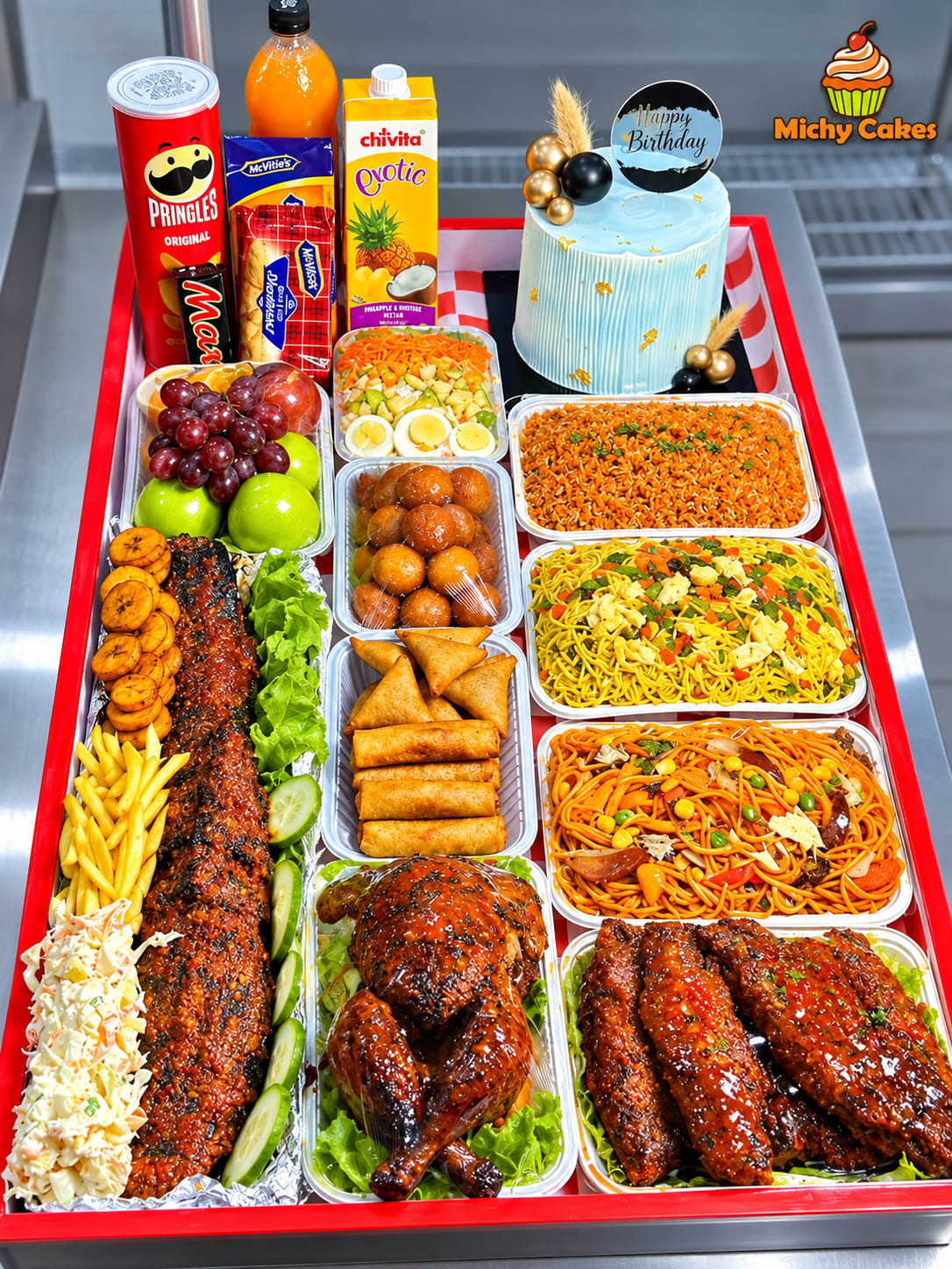 Illustration of a red party tray with rice, noodles, grilled fish, chicken, small chops, fruit, snacks and a birthday cake
