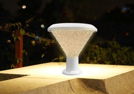 Solar LED garden light lit at night on a ledge