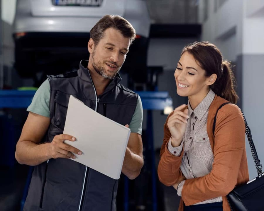 A service advisor walking a customer through the work on her vehicle