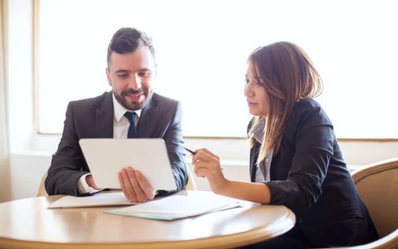 A finance manager going through loan terms with a customer at the desk
