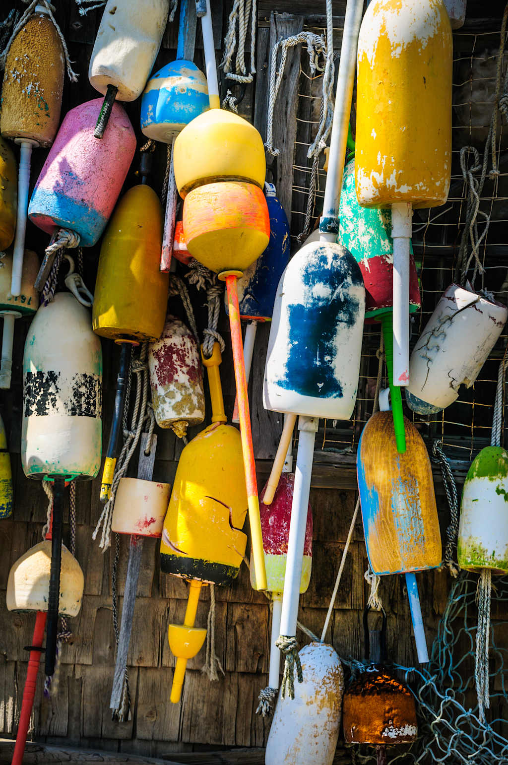 A collection of old fishing nets and colorful lobster bouys on a fish shack in Southern Maine.