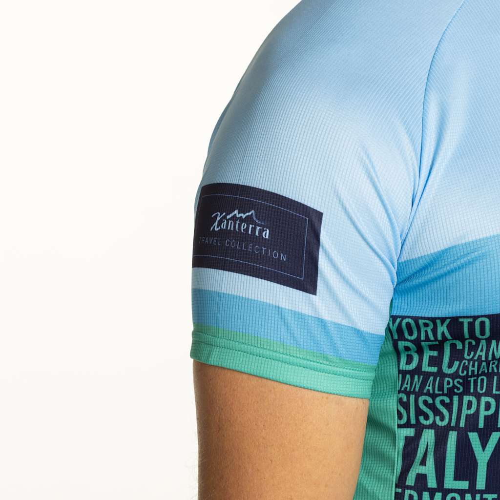 The image shows a close-up view of a person's arm wearing a light blue shirt with a Xanterra logo and text that mentions "Work to be clean" and "Mississippi Italy".