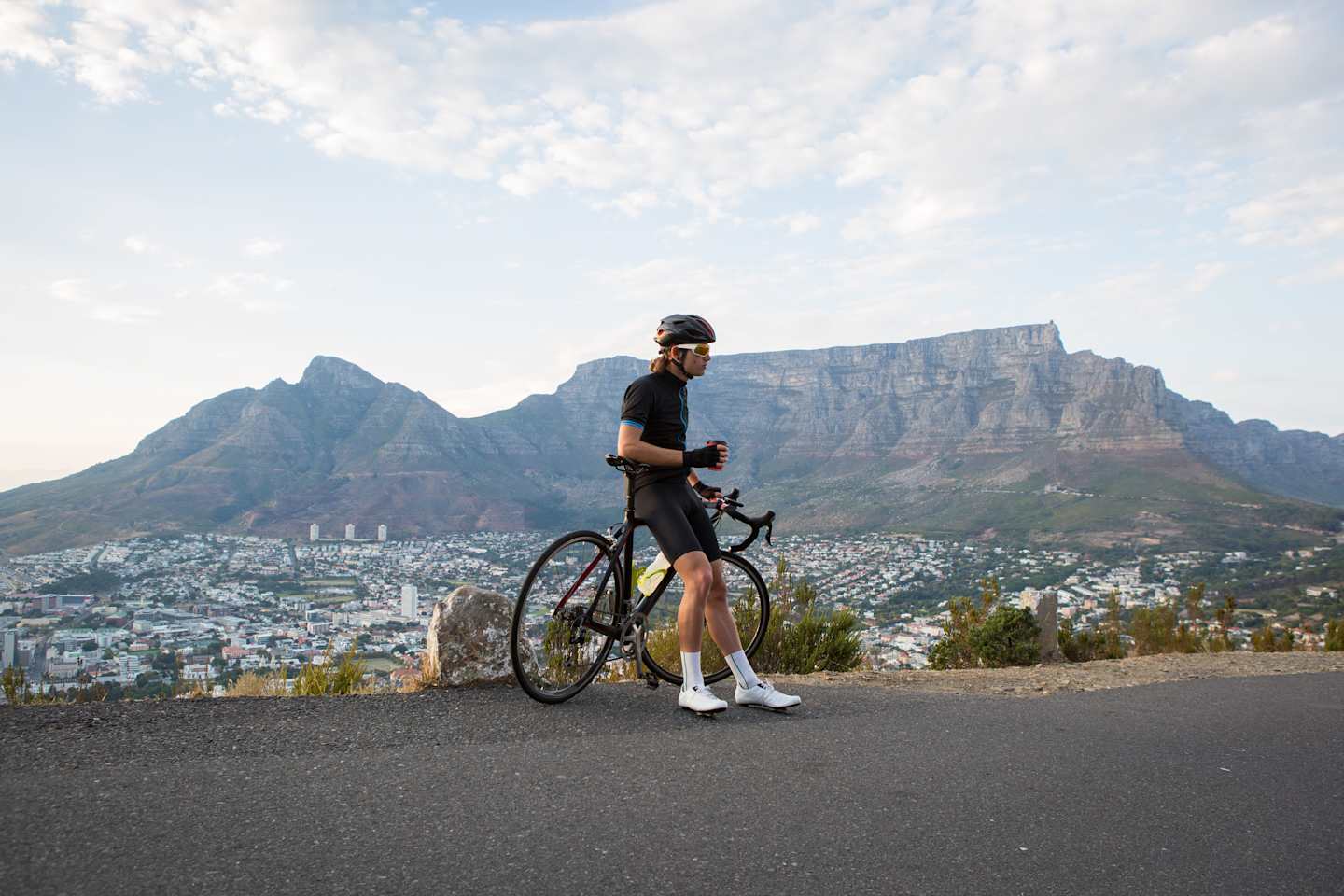 A male cyclist stops to admire the view over Cape Town and has a coffee break