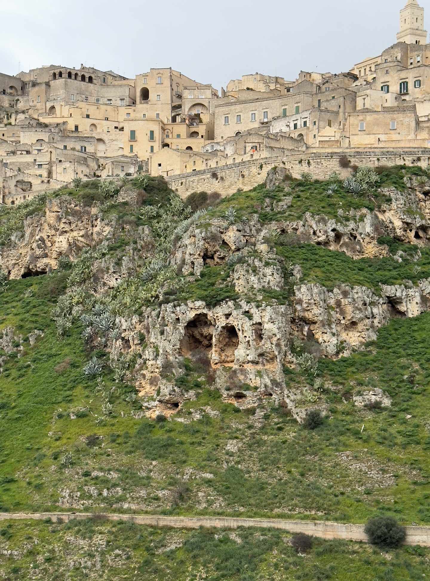 A picturesque ancient town nestled among rocky cliffs, with a mix of traditional buildings and natural landscapes in the foreground and background.
