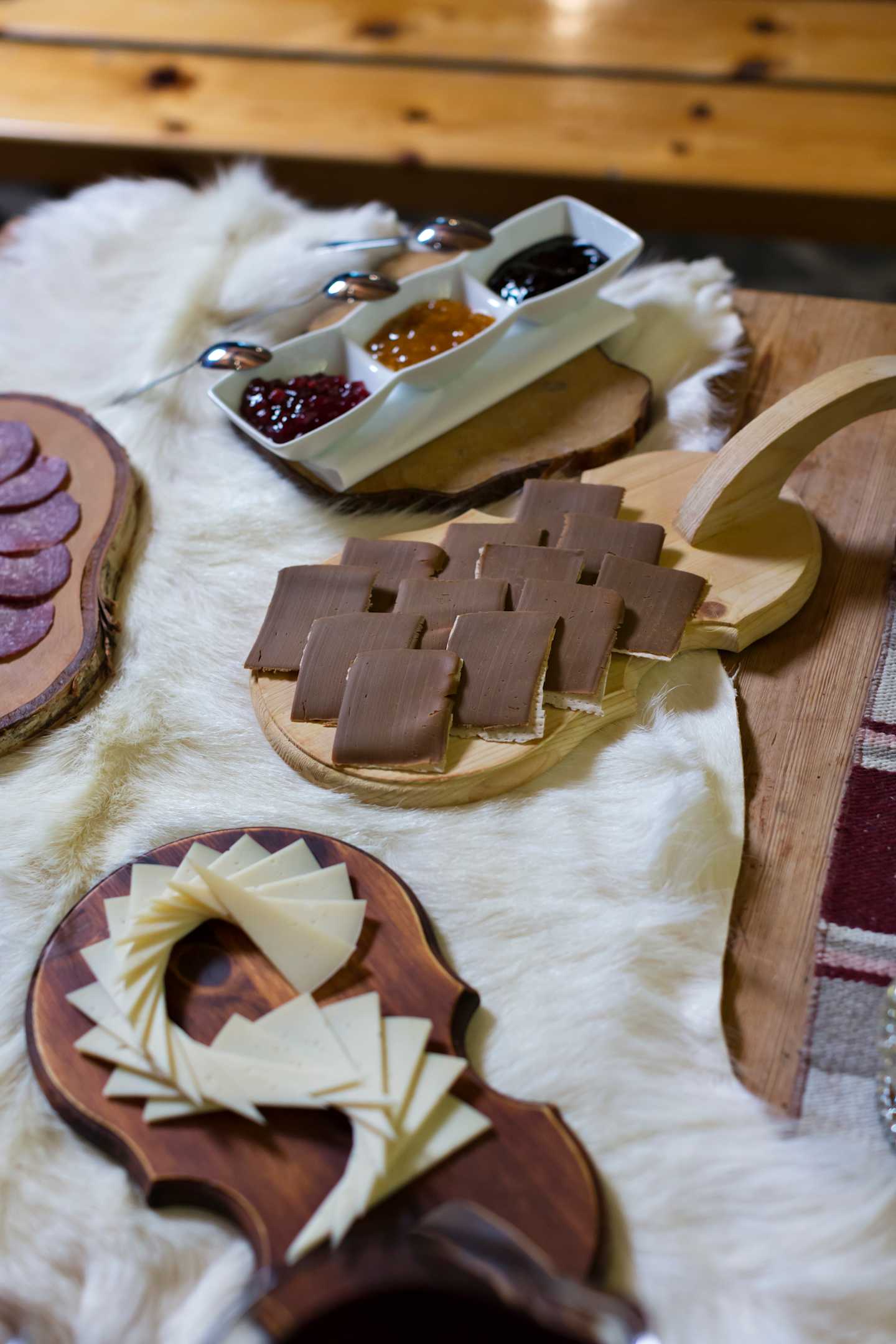The image shows various pieces of dough or pastry on a wooden surface, along with a plate of sauces or toppings, suggesting the preparation of some kind of baked goods or pastries.