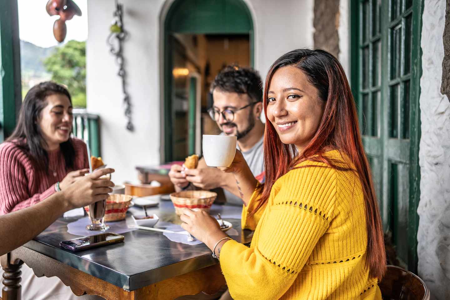 A group of friends enjoying drinks and snacks on a cozy outdoor patio, surrounded by a warm and inviting atmosphere.