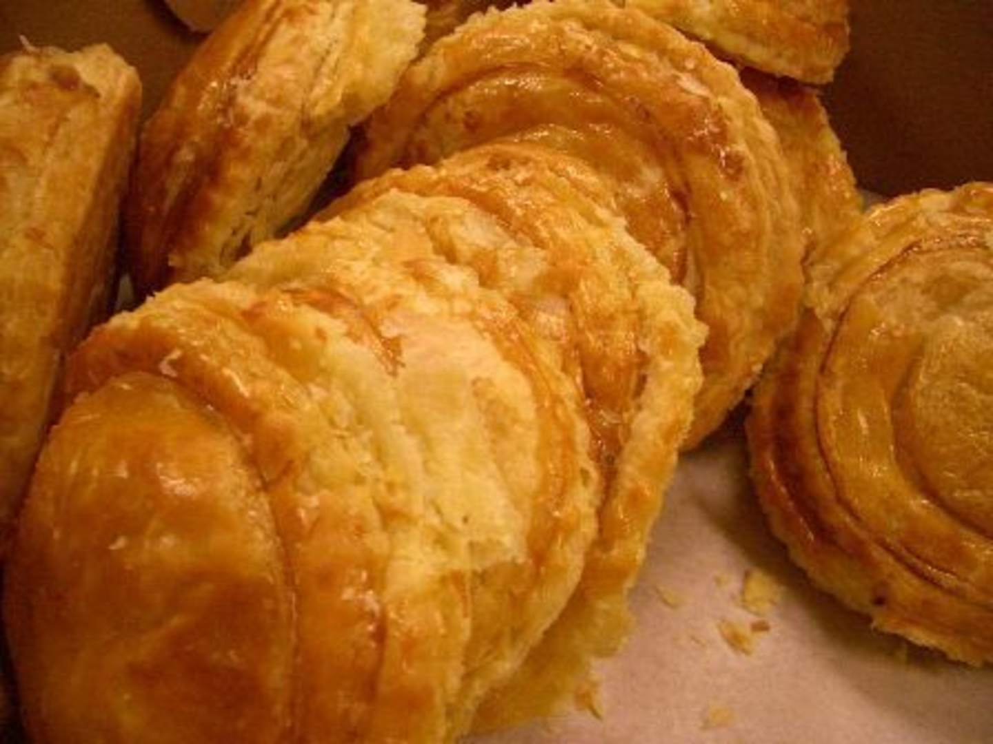 Freshly baked golden-brown croissants are the focal point of the image, arranged on a surface with a textured background.