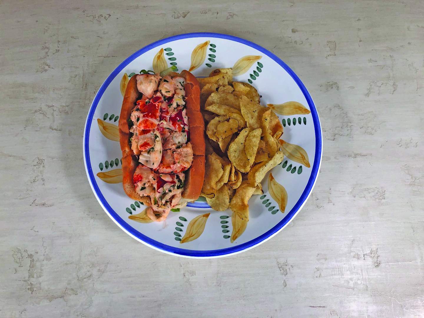 The image shows a plate with various food items, including a red and white salad, some fried or baked potato slices, and what appears to be a concrete or stone surface in the background.