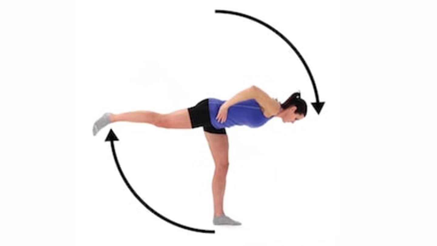 A person in a blue outfit performing a dynamic yoga or gymnastics pose against a plain white background.