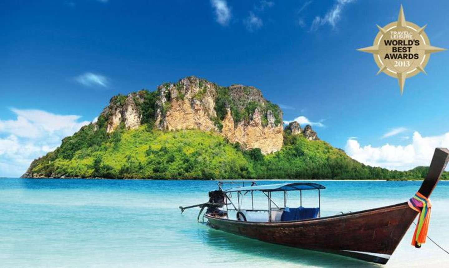 A traditional wooden boat floats on the turquoise waters of a tropical bay, with a lush, mountainous island rising in the background under a clear blue sky.